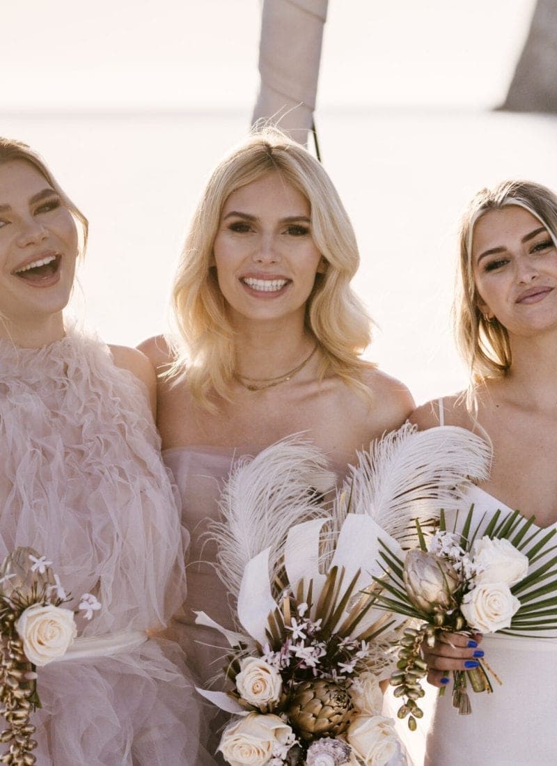 Strandhochzeit Mallorca – dekorierter Blumenbogen im Sand bei Sonnenuntergang mit Blick aufs Meer