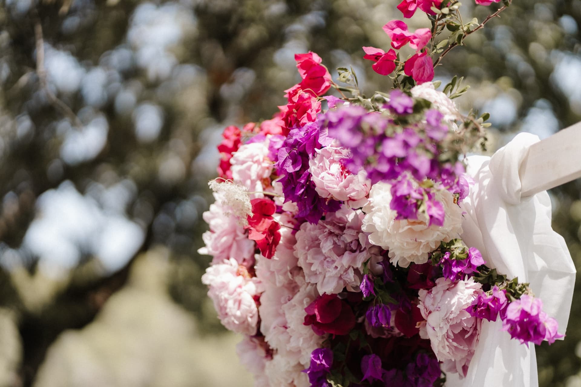 Blumenschmuck am Zeremoniebogen mit fließender Stoffdrapierung