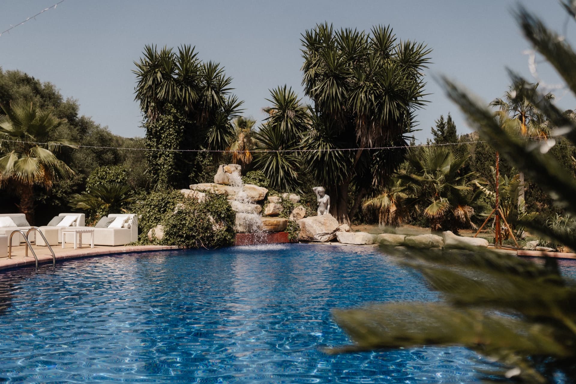 Poolbereich der Finca mit Palmen und Loungemöbeln